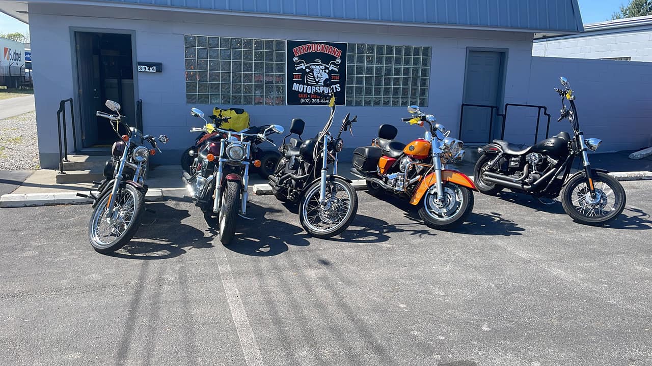 A Collection Of Motorcycles Parked Neatly In Front Of A Modern Building