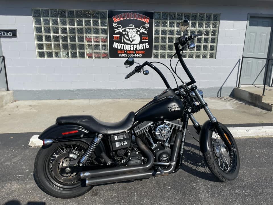 A Black Motorcycle Is Parked In Front Of A Modern Building