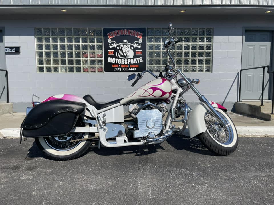 A Motorcycle Featuring A Vibrant Pink And White Paint Job